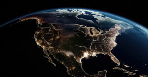 A nighttime view of the United States from space, showing illuminated urban areas and dark rural regions, symbolizing broadband connectivity gaps and efforts to bridge the digital divide.